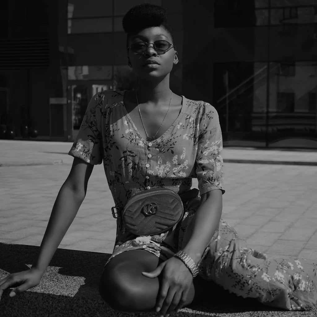 Woman wearing Gucci belt bag styled with floral dress from the EDRM Gucci collection, showcasing luxury streetwear UK and authentic designer clothes UK available at your online luxury fashion store