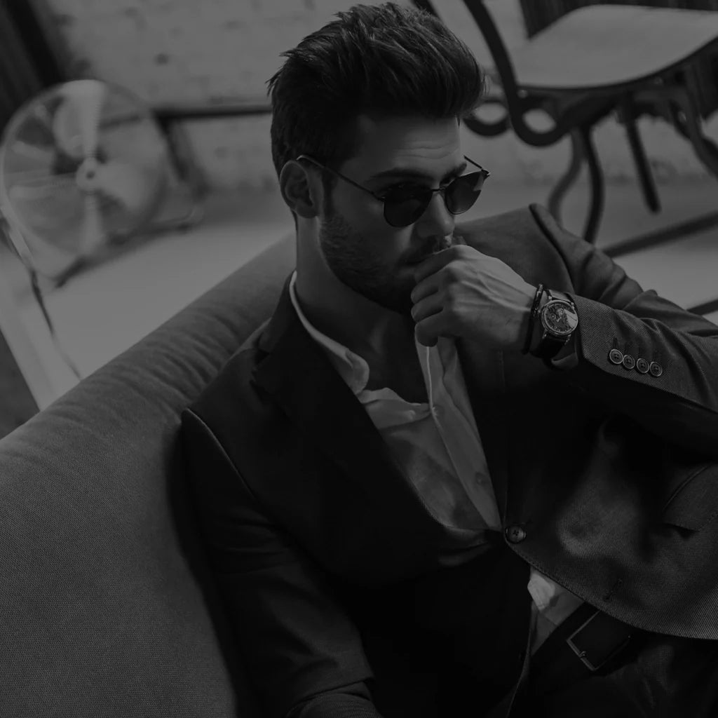 Man sitting in a tailored luxury suit showcasing affordable fashion in Essex.