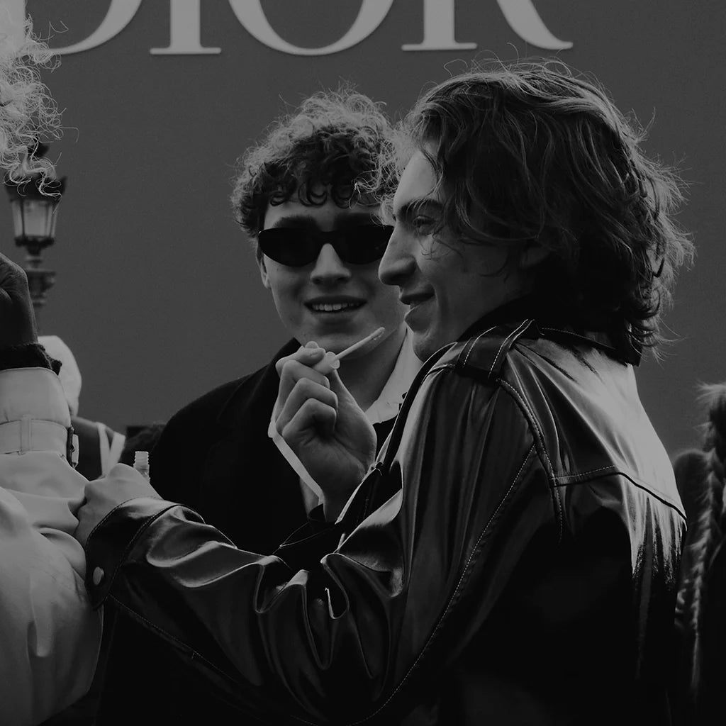 Group of people outside Dior storefront wearing luxury fashion from the EDRM Dior collection, showcasing premium designer clothes and authentic designer clothes UK style