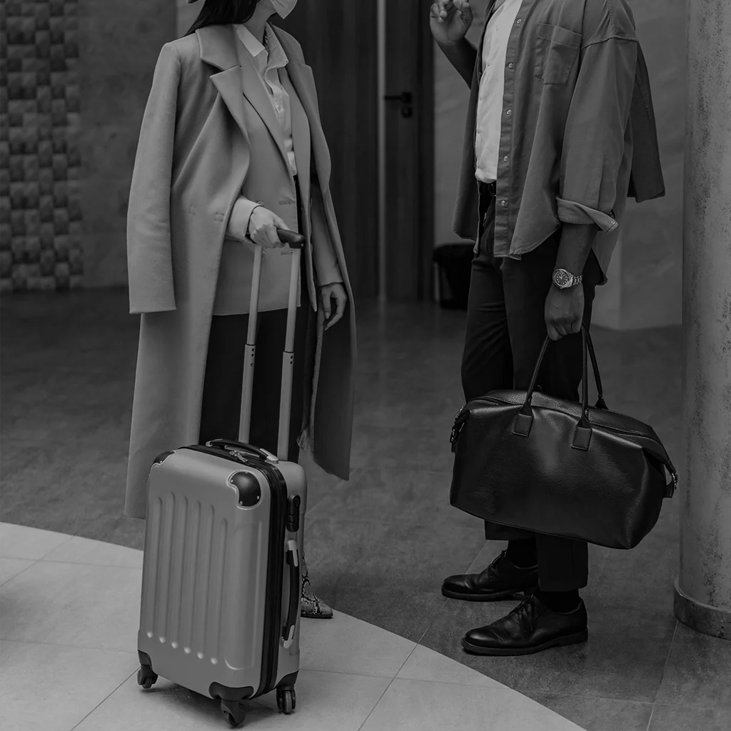man holding black leather duffle bag in hotel lobby